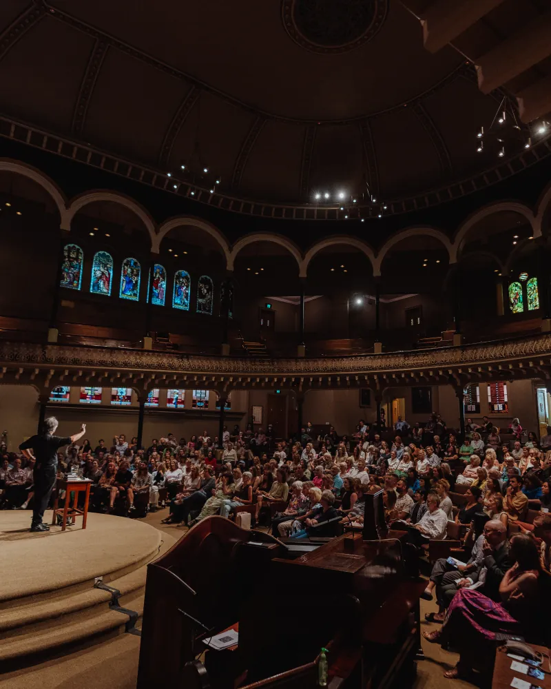 A grand hall filled for an evening talk